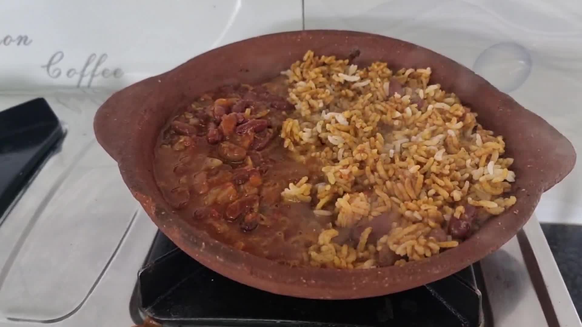 A picture of step 4 of Beans and rice sizzler in a clay pan.