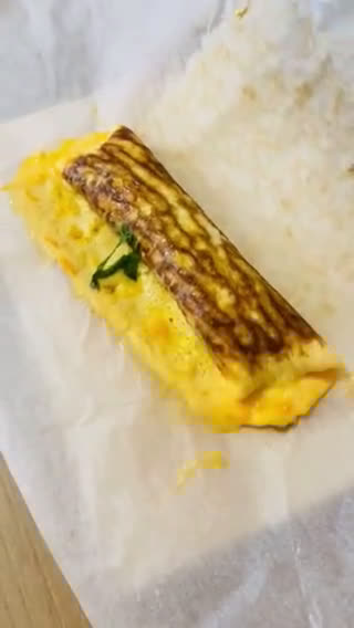 A picture of step 3 of Tamagoyaki in a round pan - Parchment Paper Trick!.